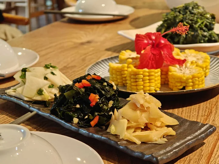 Plates of colorful vegetables, corn and other vegetarian dishes