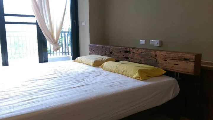 A king-size bed in a private room with a balcony door